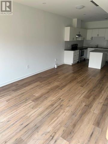 Welland (Lincoln/Crowland) apartment for rent - A kitchen with white cabinets and a wooden floor.