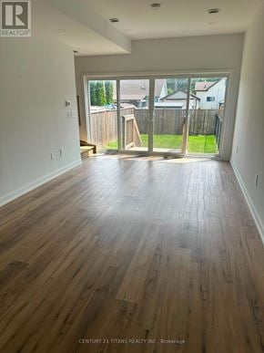 Welland (Lincoln/Crowland) apartment for rent - A room with wooden flooring and a view of a backyard through the sliding glass door.