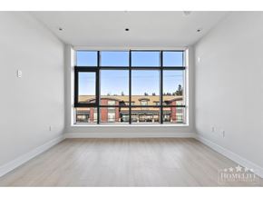 Surrey apartment for rent - A large empty room with a view of a building outside the window.