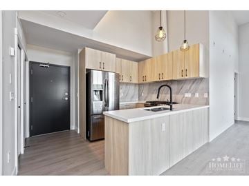 Surrey apartment for rent - A modern kitchen with a black fridge and wooden cabinets.