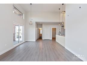 Surrey apartment for rent - A spacious living room with wood flooring and white walls.