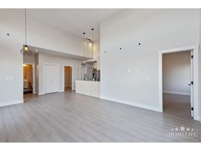 Surrey apartment for rent - A spacious room with wooden floors and white walls.