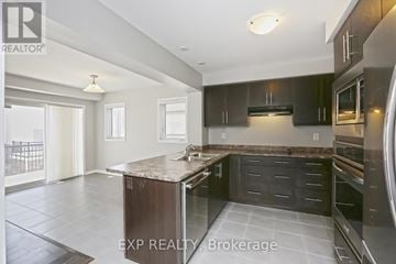 Brampton (Northwest Brampton) townhouse for rent - A modern kitchen with dark cabinets and a central island.