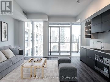 Toronto (Bay Street Corridor) condo for rent - A modern living room with a grey sofa and a wooden coffee table.