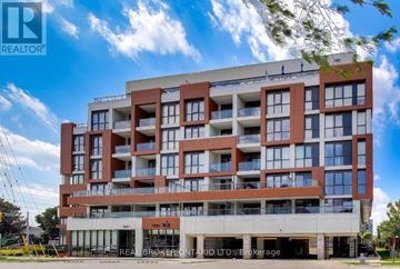 Burlington (Uptown) condo for rent - A large, modern apartment building with a clear blue sky above it.