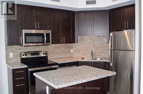 Burlington (Uptown) condo for rent - A kitchen with a granite countertop and stainless steel appliances.