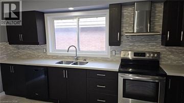 Hamilton apartment for rent - A kitchen with black cabinets and stainless steel appliances.