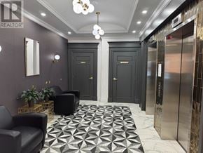 Toronto (Willowdale East) condo for rent - A hallway with a black and white floor, a black door, and a gold console.