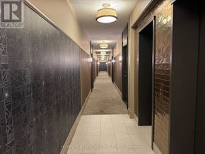 Toronto (Willowdale East) condo for rent - A long hallway with a wall on the left side that has a geometric pattern on it.
