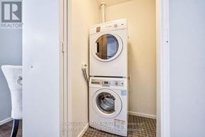 Toronto (Bay Street Corridor) condo for rent - A washer and dryer stacked on top of each other in a small laundry room.