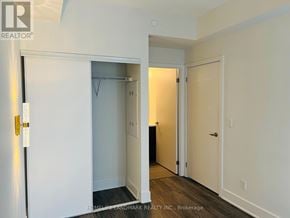 Toronto (Don Valley Village) condo for rent - A white door with a gold handle is open to a room with a black wardrobe.