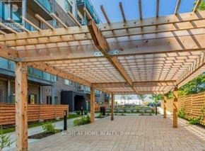 Toronto (Malvern) condo for rent - A wooden pergola is in the foreground of a residential area.