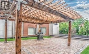 Toronto (Malvern) condo for rent - A wooden pergola over a patio with a brick floor.