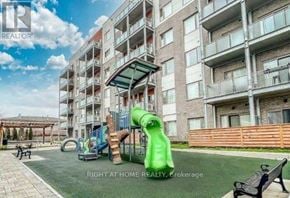 Toronto (Malvern) condo for rent - A playground area with a green slide and a wooden fence in front of apartment buildings.