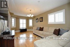 Oshawa (Eastdale) apartment for rent - A living room with a couch, a table, and a chandelier.