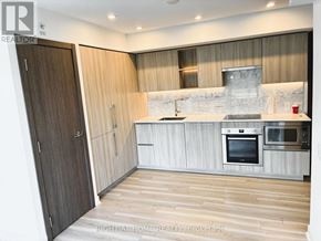 Toronto (Waterfront Communities) condo for rent - A modern kitchen with wooden floors and a marble backsplash.