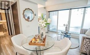 Toronto (Waterfront Communities) condo for rent - A modern living room with a glass table and a mirror on the wall.