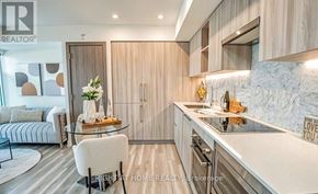 Toronto (Waterfront Communities) condo for rent - A modern kitchen with a glass table and a white chair.