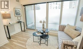 Toronto (Waterfront Communities) condo for rent - A living room with a glass door leading to a balcony.
