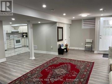 Toronto (Highland Creek) apartment for rent - A living room with a rug in the middle and a kitchen in the background.