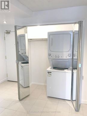 Toronto (Church-Yonge Corridor) condo for rent - A white washer and dryer are in a room with a realtor sign.