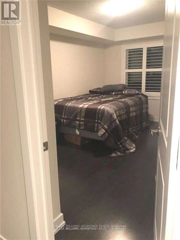 Toronto (Mimico) townhouse for rent - A bedroom with a bed covered in a plaid comforter.