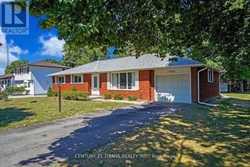 Clarington (Courtice) apartment for rent - A house with a red brick exterior and a white garage door is for sale.