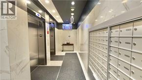 Toronto condo for rent - A hallway with a row of mailboxes on the right and a bench in the middle.