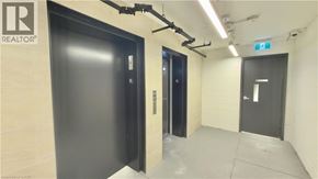Toronto condo for rent - A hallway with two doors and a REALTOR sign on the wall.