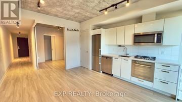 Toronto (Waterfront Communities) condo for rent - A kitchen with white cabinets and a microwave above the stove.