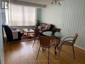 Toronto (Steeles) condo for rent - A living room with a glass table and chairs.