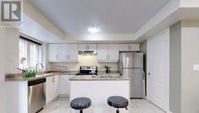 Markham (Cornell) townhouse for rent - A kitchen with white cabinets and a stainless steel dishwasher.