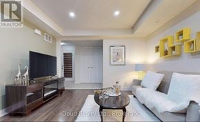 Markham (Cornell) townhouse for rent - A modern living room with a grey sofa, a wooden coffee table, and a flat-screen TV.