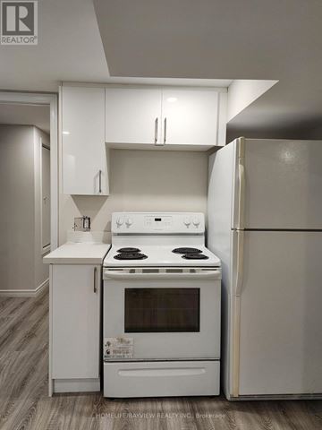 East Gwillimbury (Holland Landing) apartment for rent - A white kitchen with a stove and refrigerator.