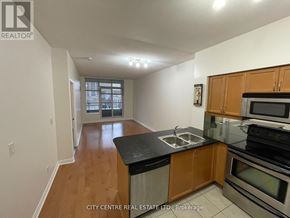 Mississauga (City Centre) condo for rent - A kitchen with wooden cabinets and black countertops.