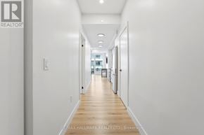 Kitchener condo for rent - A long hallway with white walls and wood floors.
