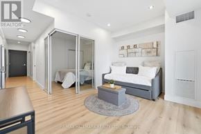 Kitchener condo for rent - A modern bedroom with a bed, a couch, and a coffee table.