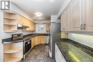 Toronto (Banbury-Don Mills) apartment for rent - A kitchen with wooden cabinets and black appliances.