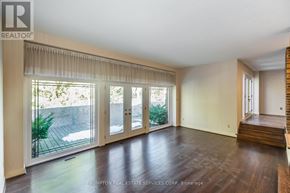Toronto (Banbury-Don Mills) apartment for rent - A spacious room with wooden floors and sliding glass doors leading to a backyard.