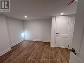 Toronto (East York) multi-family for rent - A room with a white door and wooden flooring.
