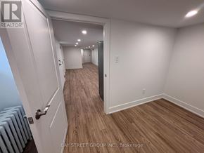 Toronto (East York) multi-family for rent - A hallway with wooden floors and white walls.