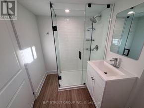 Toronto (East York) multi-family for rent - A white bathroom with a walk in shower and a sink.