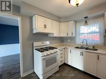 Barrie (Cundles East) apartment for rent - A kitchen with white cabinets and a stove top oven.