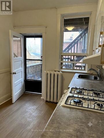 Toronto (Dufferin Grove) triplex for rent - A kitchen with a stove, sink and a window.