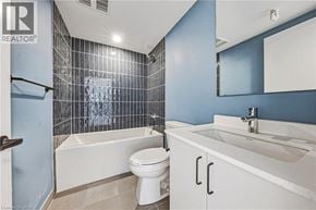 Hamilton apartment for rent - A white toilet sits in a bathroom with blue walls and a white sink.