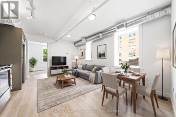 Hamilton (Corktown) multi-family for rent - A well-lit, modern living room with a dining area and kitchen in the background.