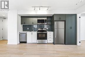 Hamilton (Corktown) multi-family for rent - A modern kitchen with stainless steel appliances and wooden flooring.