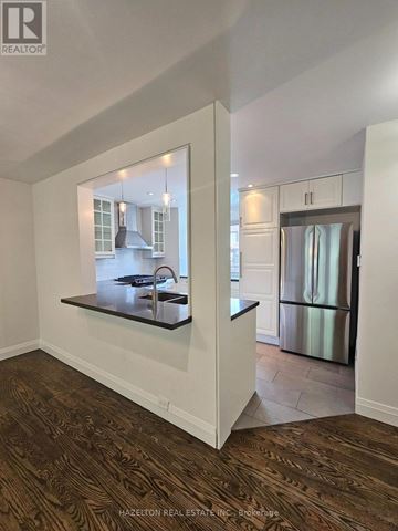 Mississauga (Clarkson) townhouse for rent - A kitchen with a refrigerator and a countertop with a sink.