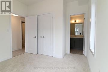 Guelph (Pineridge/Westminster Woods) townhouse for rent - A white bedroom with a large closet and a mirror on the wall.