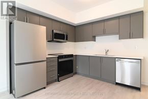 Guelph (Pineridge/Westminster Woods) townhouse for rent - A modern kitchen with a refrigerator, oven, microwave, sink, and cabinets.